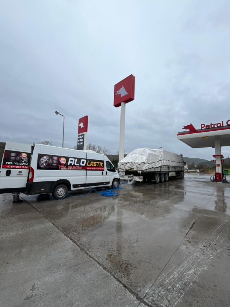 Otoyol üzerindeki bir benzin istasyonunda dorseli tır için yerinde lastik hizmeti sunan Alo Lastik mobil aracı.